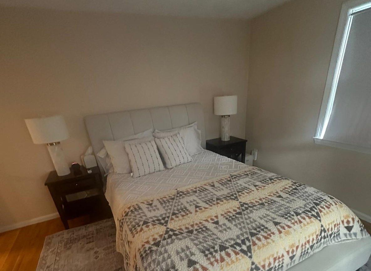 Freshly cleaned bedroom with wood furnishings by Allegry Cleaning Services